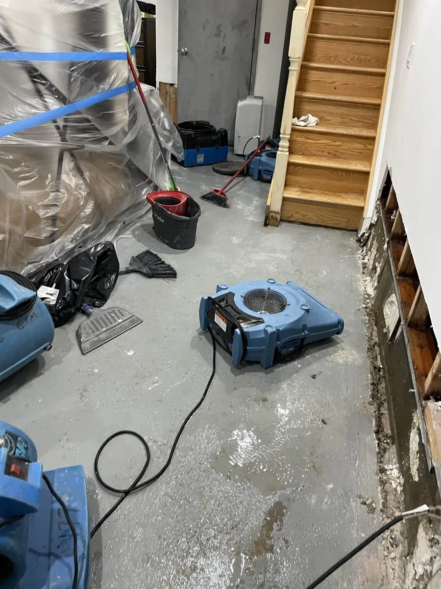 Air movers drying a basement hallway after water came in