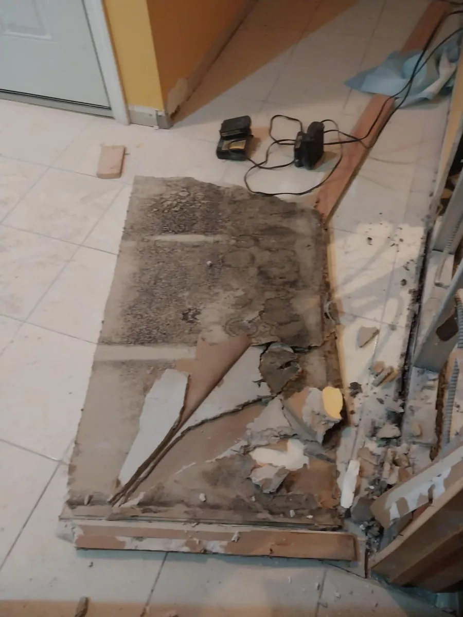 Moldy, water-damaged drywall panel pulled off a basement wall after a water heater leak in Marine Park, Brooklyn