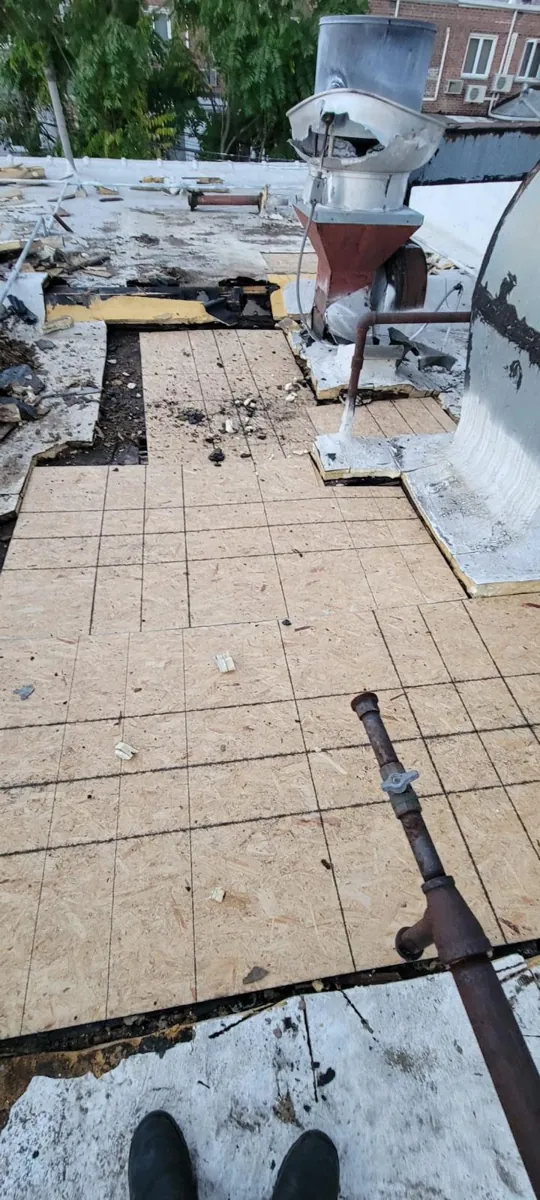 Prep work over a fire-damaged section of flat roof before tarping